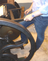 Carl Smith "Kicking the
                  treadle" on an old platen press