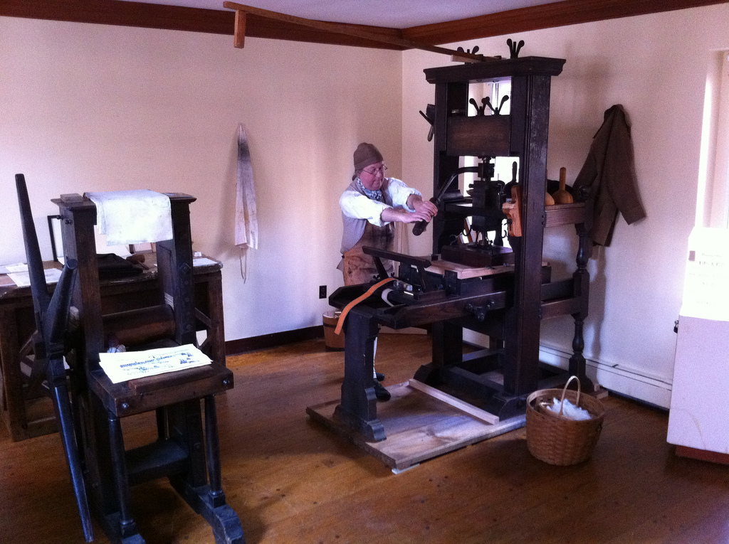Docent operating the Common Press at The
                Printing Office of Edes & Gill in Boston